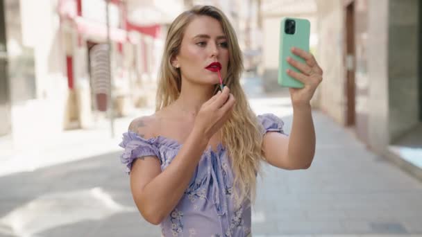 Young Beautiful Hispanic Woman Using Smartphone Mirror Make Lips Street — 图库视频影像