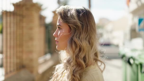 年轻的金发女子自信地站在街上笑 — 图库视频影像