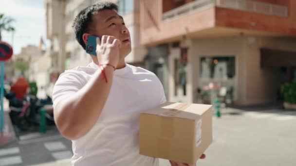 Joven Mensajero Chino Hablando Paquete Celebración Teléfonos Inteligentes Calle — Vídeos de Stock