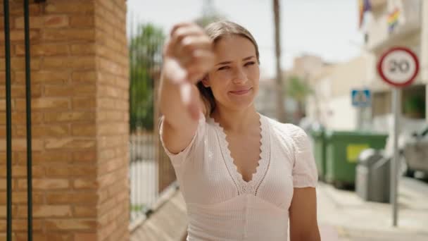Молодая Белая Женщина Делает Негативный Знак Большими Пальцами Улице — стоковое видео