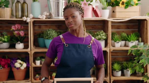 Африканська Американка Флористка Посміхається Впевнено Тримаючи Відкриту Дошку Квітку — стокове відео
