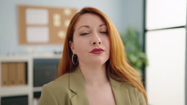 年轻的红头发女商人双手叉腰站在办公室里 — 图库视频影像