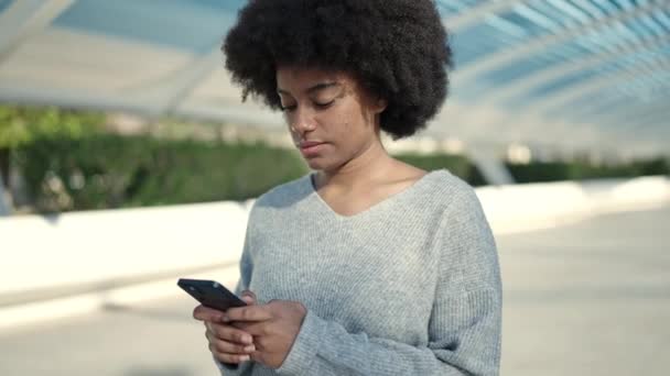 아프리카 미국인 공원에서 스마트폰을 사용하여 자신감 웃는다 — 비디오
