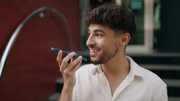 Молодий Арабський Чоловік Посміхається Впевнено Говорити Смартфону Вулиці — стокове відео