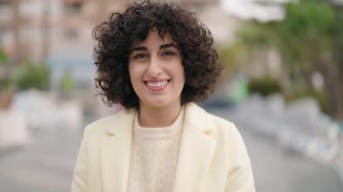Young woman smiling confident using professional camera at street