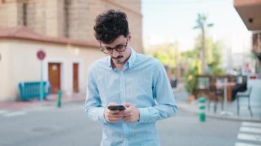 Sokakta akıllı telefon kullanan genç bir İspanyol.