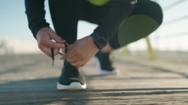 Middle age woman wearing sportswear typing shoes at street