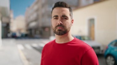 Genç İspanyol adam gülümsüyor. Kendine güveni tam. Sokakta çapraz hareketlerle duruyor.