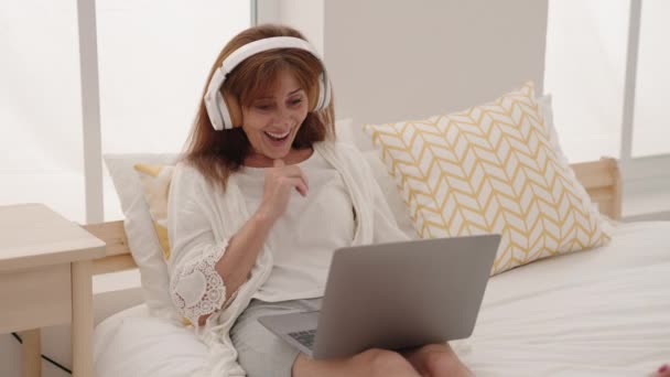 Mulher Meia Idade Usando Laptop Fones Ouvido Sentados Cama Quarto — Vídeo de Stock