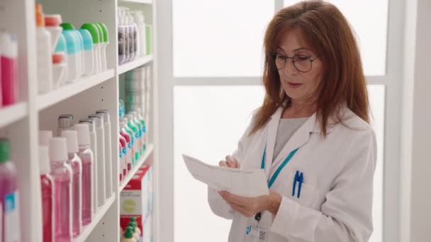 Middle Age Woman Pharmacist Holding Bottle Reading Prescription Pharmacy — Stok Video