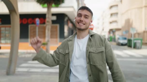 Νεαρός Ισπανός Χαμογελάει Αυτοπεποίθηση Ακούγοντας Μουσική Και Χορεύοντας Στο Δρόμο — Αρχείο Βίντεο