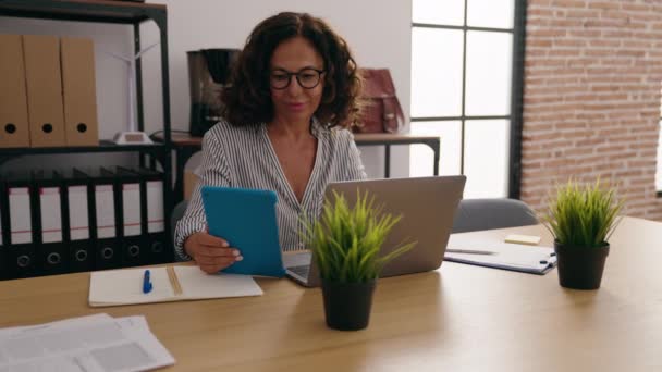 オフィスでノートパソコンやタッチパッドを使用している中年女性のビジネスワーカー — ストック動画