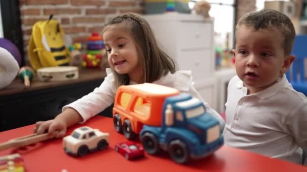 Αξιολάτρευτο Κορίτσι Και Αγόρι Παίζει Αυτοκίνητο Στο Τραπέζι Στο Νηπιαγωγείο — Αρχείο Βίντεο