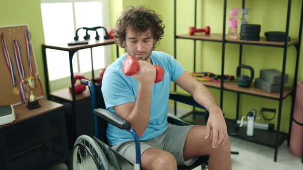 Young Hispanic Man Sitting Wheelchair Training Dumbbell Rehab Clinic — Stock video