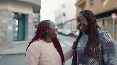 Two african american women smiling confident speaking at street