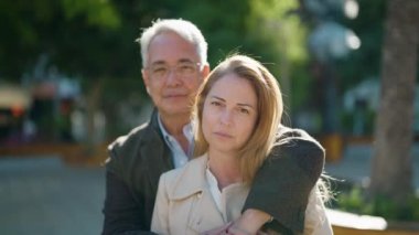 Middle age couple couple smiling confident hugging each other at park