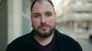 Young plus size man smiling confident standing with arms crossed gesture at street