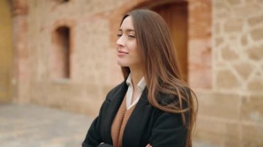 Young hispanic woman smiling confident standing with arms crossed gesture at university