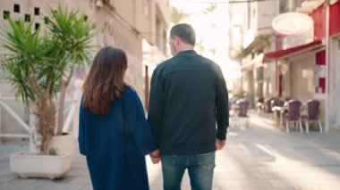 Man and woman couple hugging each other standing at street
