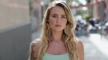 Sokakta kendine güvenen genç sarışın kadın gülümsüyor