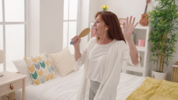 Μεσήλικας Γυναίκα Τραγουδούν Τραγούδι Χρησιμοποιώντας Βούρτσα Μικρόφωνο Στο Υπνοδωμάτιο — Αρχείο Βίντεο