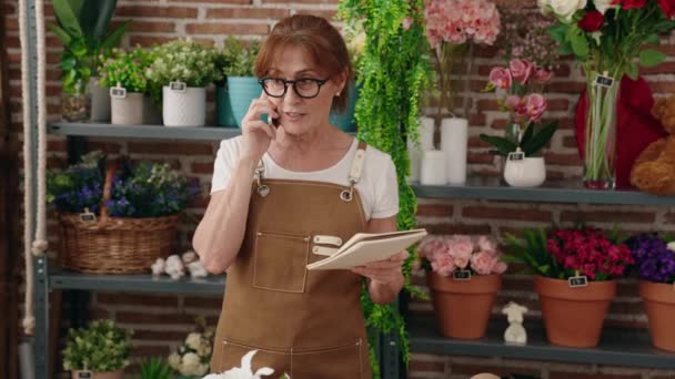 Florista Mujer Mediana Edad Hablando Smartphone Leyendo Cuaderno Tienda Flores — Vídeo de stock