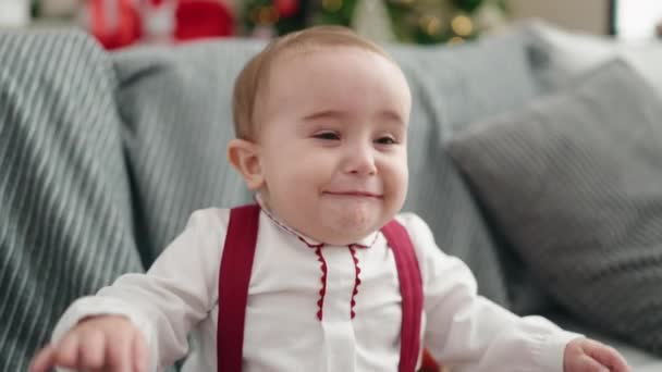 Adorable Hispanic Baby Sitting Sofa Christmas Tree Crying Home — стоковое видео