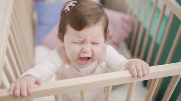 Liebenswertes Kleinkind Steht Weinend Auf Der Wiege Schlafzimmer — Stockvideo