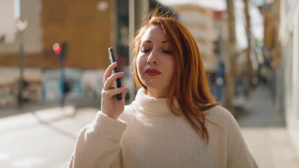 Νεαρή Κοκκινομάλλα Γυναίκα Ανησυχεί Μιλώντας Στο Smartphone Στο Δρόμο — Αρχείο Βίντεο