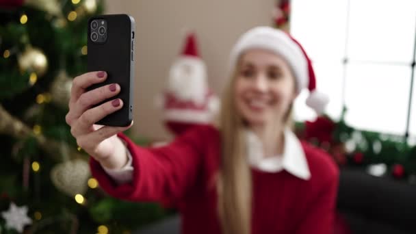 Young Blonde Woman Having Video Call Sitting Sofa Christmas Tree — стоковое видео