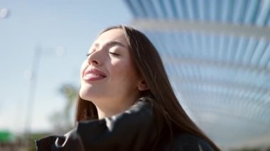 Young beautiful hispanic woman breathing with closed eyes at street