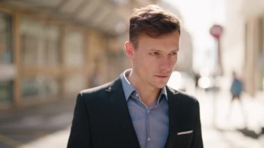 Young caucasian man with relaxed expression standing at street