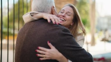 Middle age couple couple smiling confident hugging each other at street