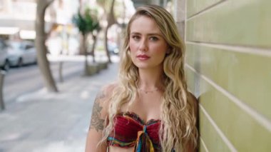 Sokakta kendine güvenen genç sarışın kadın gülümsüyor