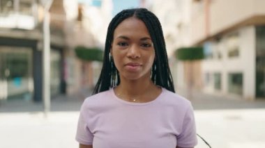 African american woman smiling confident pointing with finger to passport at street