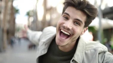 Sokakta kendinden emin gülümseyen İspanyol genç adam.