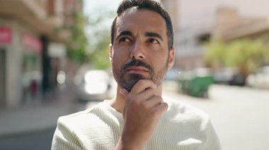 Sokakta şüpheli bir ifadeyle duran İspanyol genç adam.