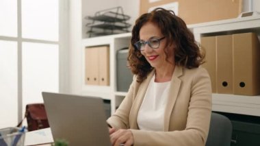 Middle age woman business worker using laptop working at office