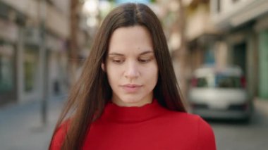 Young woman with relaxed expression standing at street
