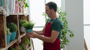 Middle age man florist smiling confident standing with arms crossed gesture at florist