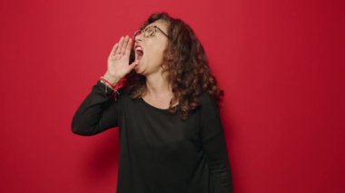 Middle age woman screaming over red background