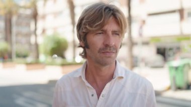 Sokakta duran rahat yüzlü genç adam.