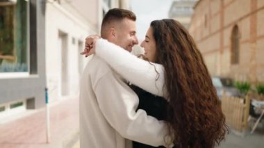 Young couple smiling confident dancing at street