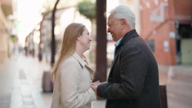 Middle age couple couple smiling confident standing together at street