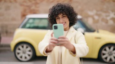 Young woman smiling confident making selfie by the smartphone at street