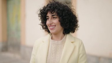 Sokakta ciddi bir ifadeyle duran genç bir kadın.