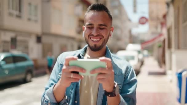 Młody Latynos Uśmiecha Się Pewnie Oglądając Wideo Smartfonie Ulicy — Wideo stockowe