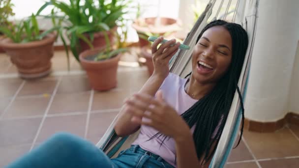 Afrikaans Amerikaanse Vrouw Luisteren Audioboodschap Door Smartphone Liggend Hangmat Thuis — Stockvideo