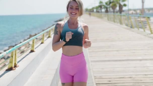 Νεαρή Ξανθιά Γυναίκα Τρέχει Και Ψάχνει Χρονόμετρο Στην Παραλία — Αρχείο Βίντεο