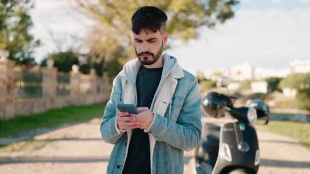 Молодий Іспаномовний Чоловік Посміхається Впевнено Використовуючи Смартфон Вулиці — стокове відео
